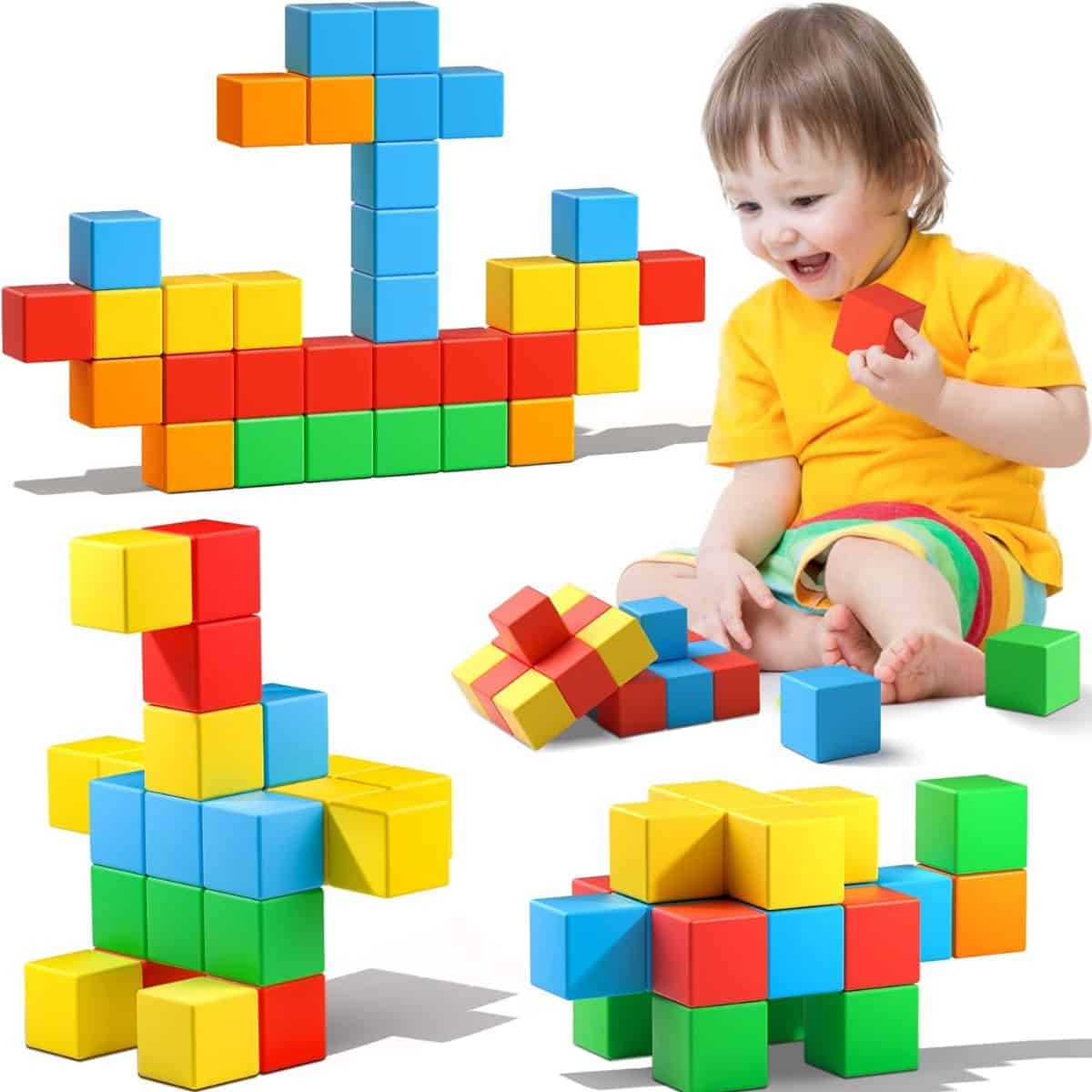 Toddler playing with colorful magnetic building blocks, shown with several completed block creations in bright red, blue, yellow, and green.