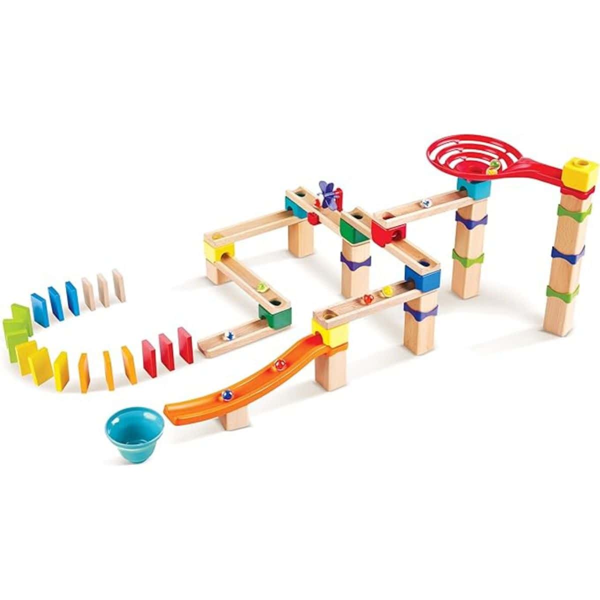A colorful wooden marble run set with ramps, blocks, a spiral drop, and domino pieces arranged in a chain, ready for marbles to roll through the course.