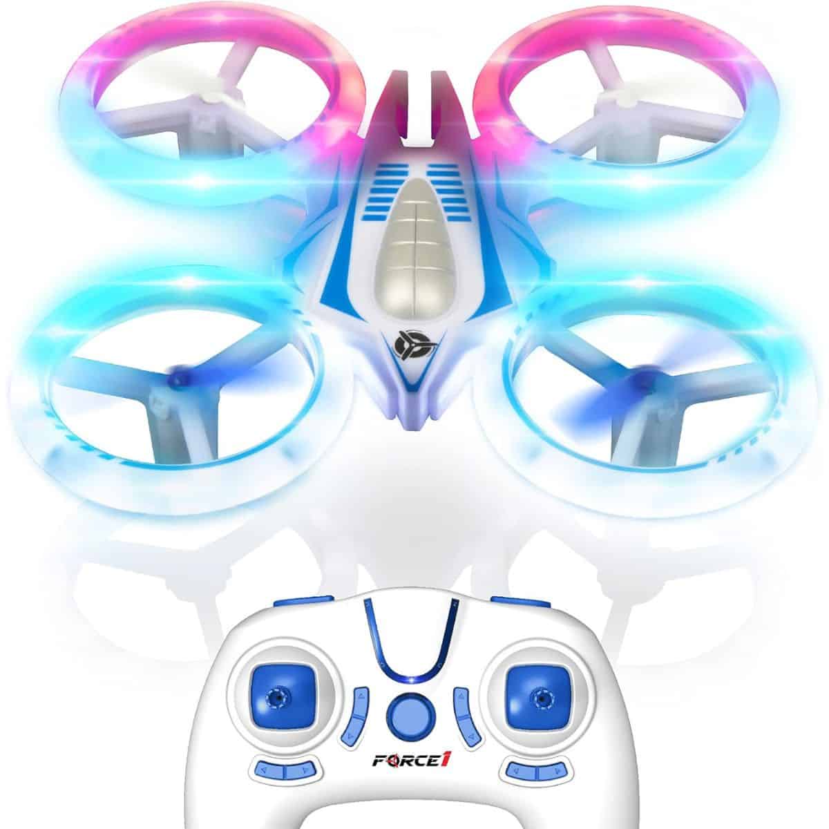 A small kids drone with glowing blue and pink LED propellers shown above a matching white and blue remote control.