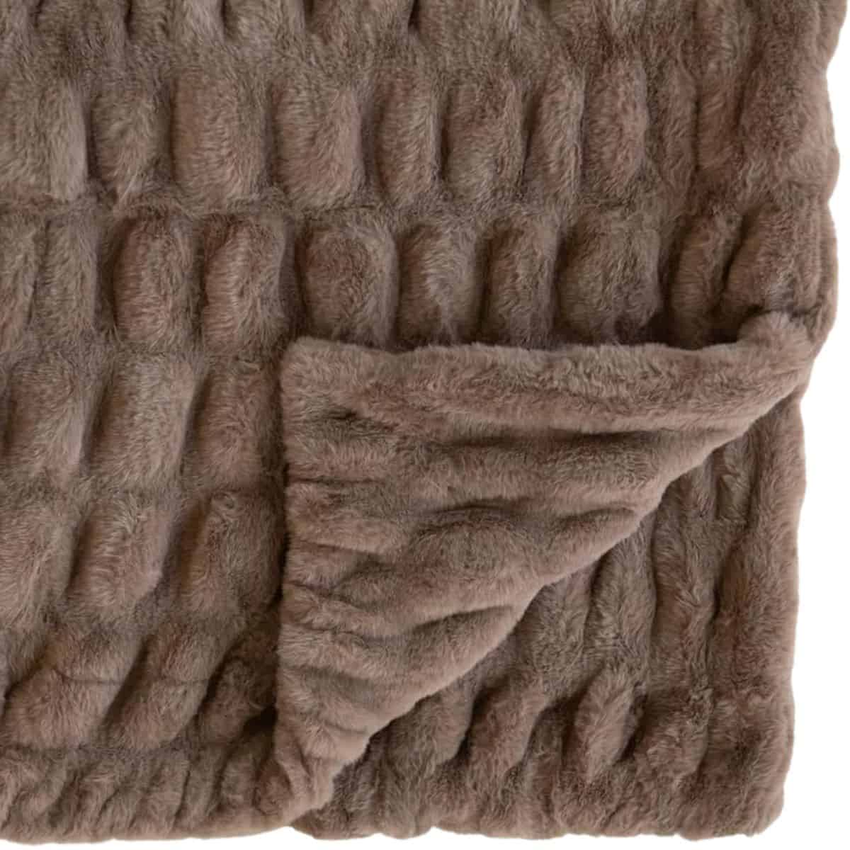 A soft, textured plush blanket shown folded with one corner turned over to display the thick, fuzzy fabric on both sides.