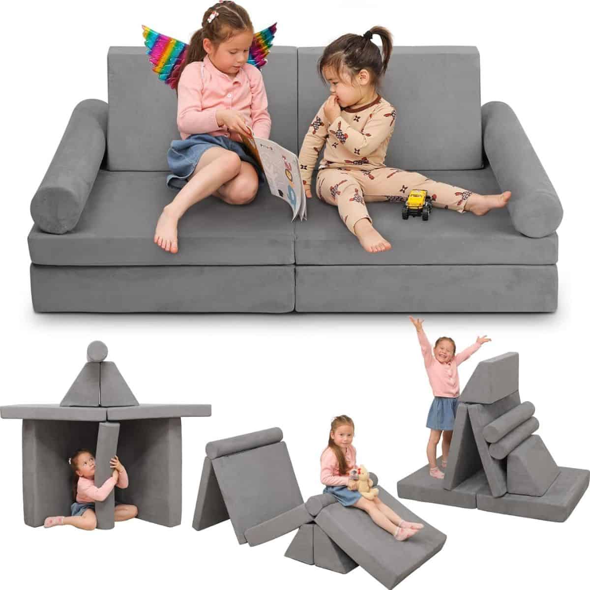 Children playing with a gray modular play couch shown as a sofa and rearranged into different shapes like a fort, slide, and climbing setup.