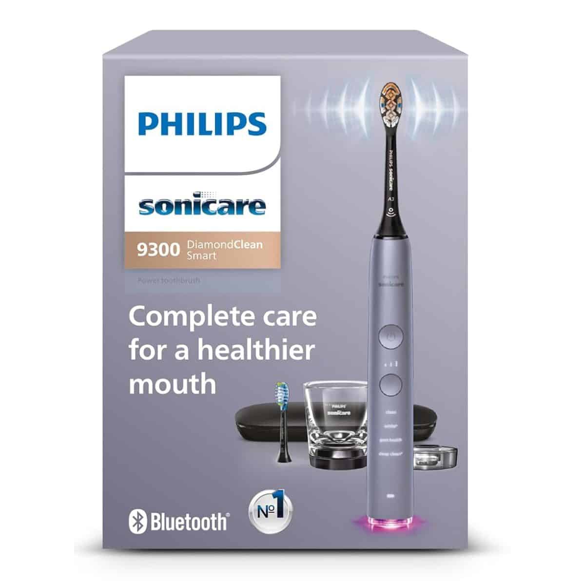 A Philips Sonicare electric toothbrush set in its box, showing the smart toothbrush handle, brush heads, charging glass, travel case, and accessories.