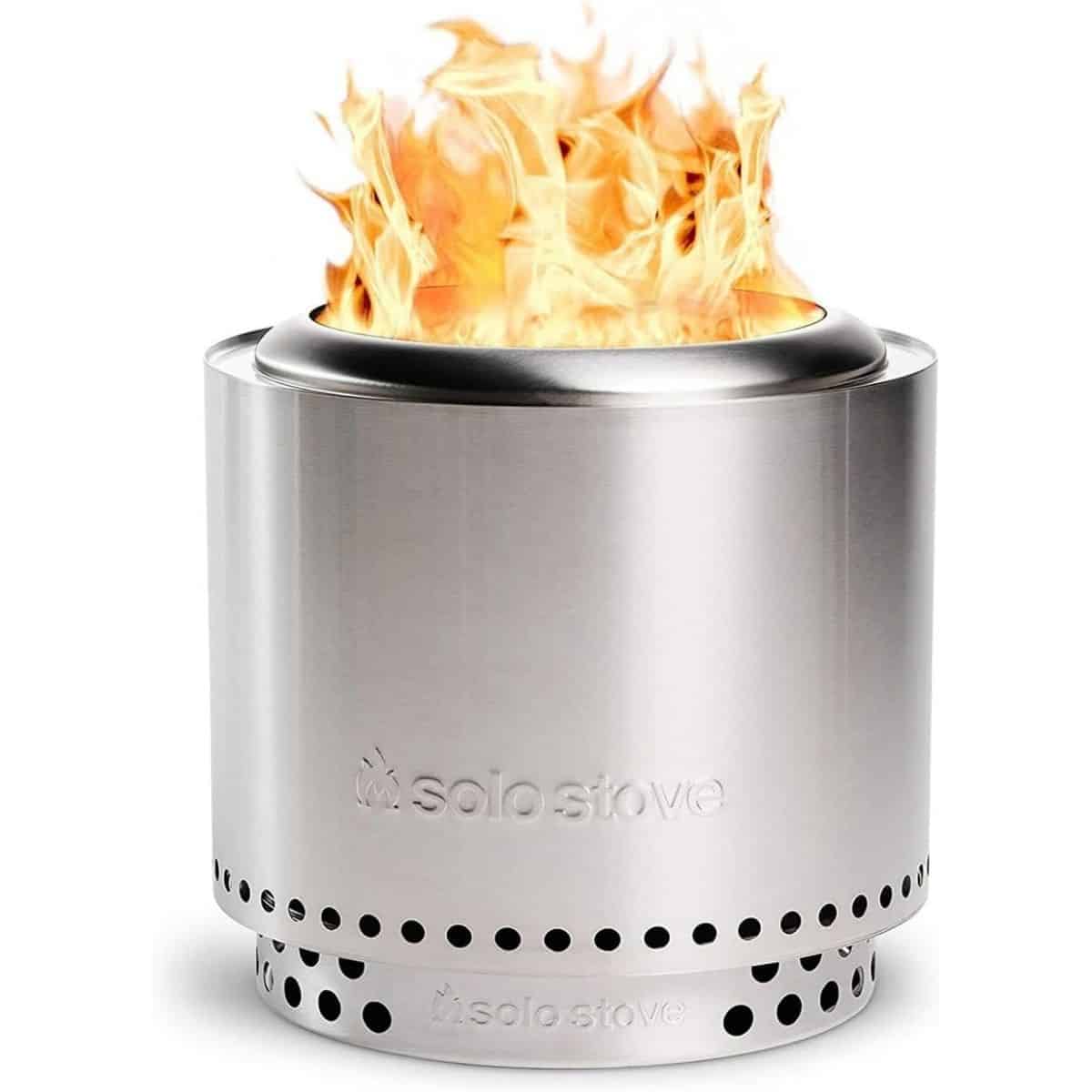 Stainless steel Solo Stove Ranger fire pit with bright flames burning from the open top.