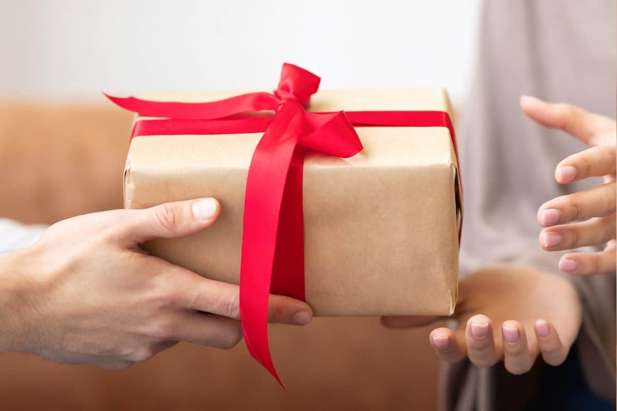 One person handing a gift to another.