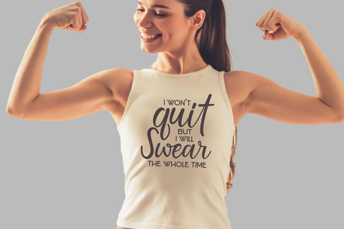 A flexing woman wearing a tank top that reads - I won't quit but I will swear the whole time.