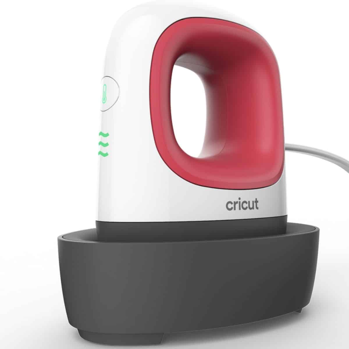 Cricut EasyPress Mini heat press sitting on its base, a compact handheld tool used for heat transfer vinyl and small iron-on craft projects.