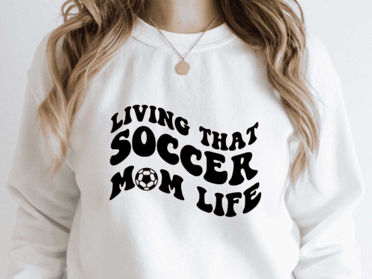 A T-shirt with a design that reads living that soccer mom life.