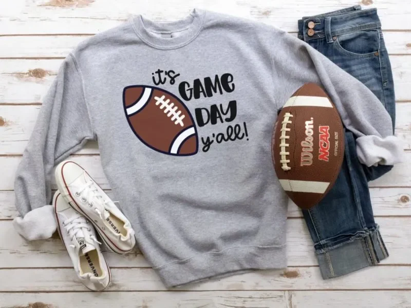 A T-shirt with a design that reads it's game day y'all!