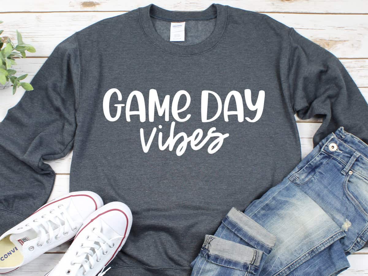A T-shirt with a design that reads game day vibes.