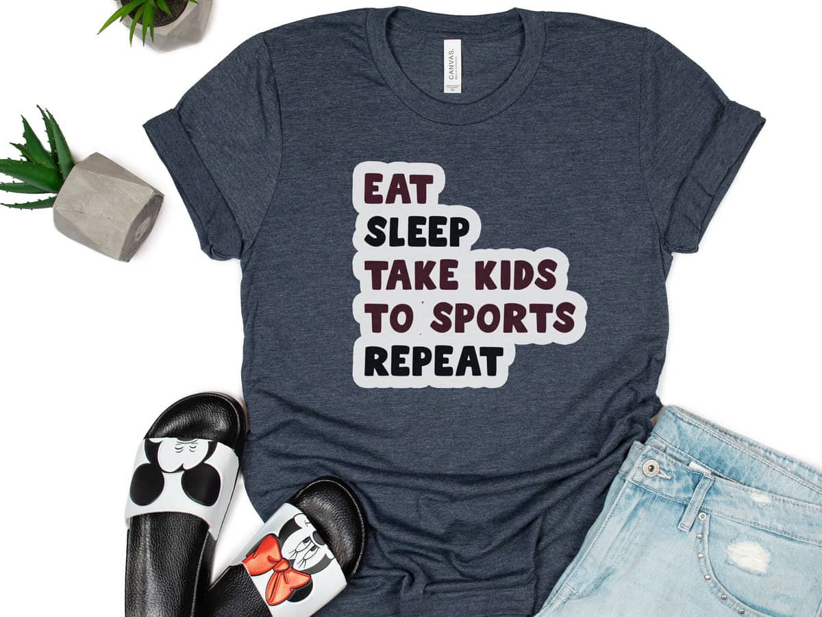 A T-shirt with a design that reads eat sleep take kids to sports repeat.