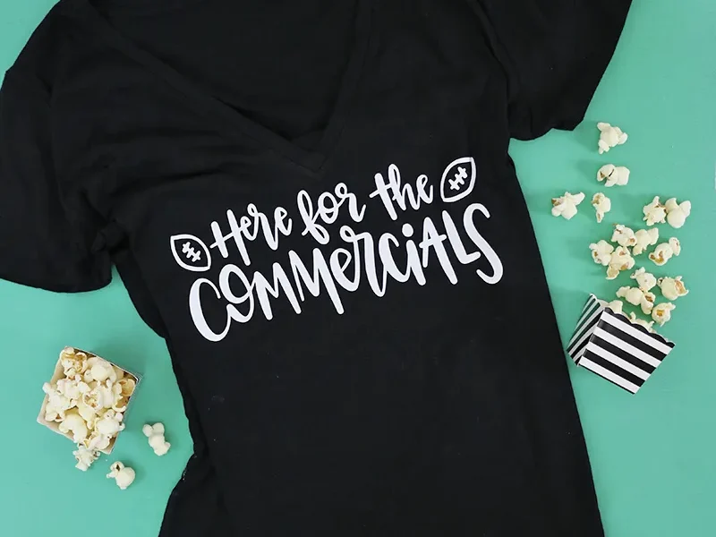 A T-shirt with a design that reads here for the commercials.