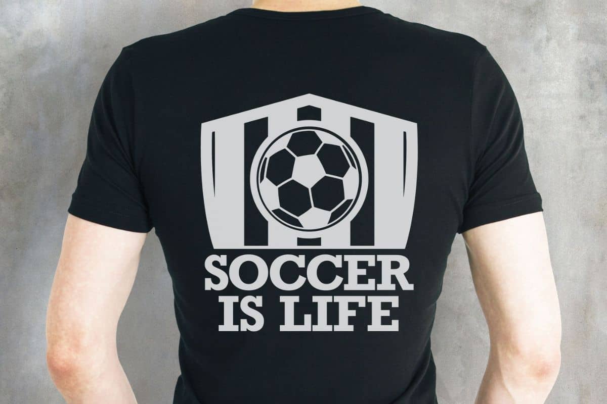 A man wearing a black t-shirt with a design on the back that reads soccer is life.