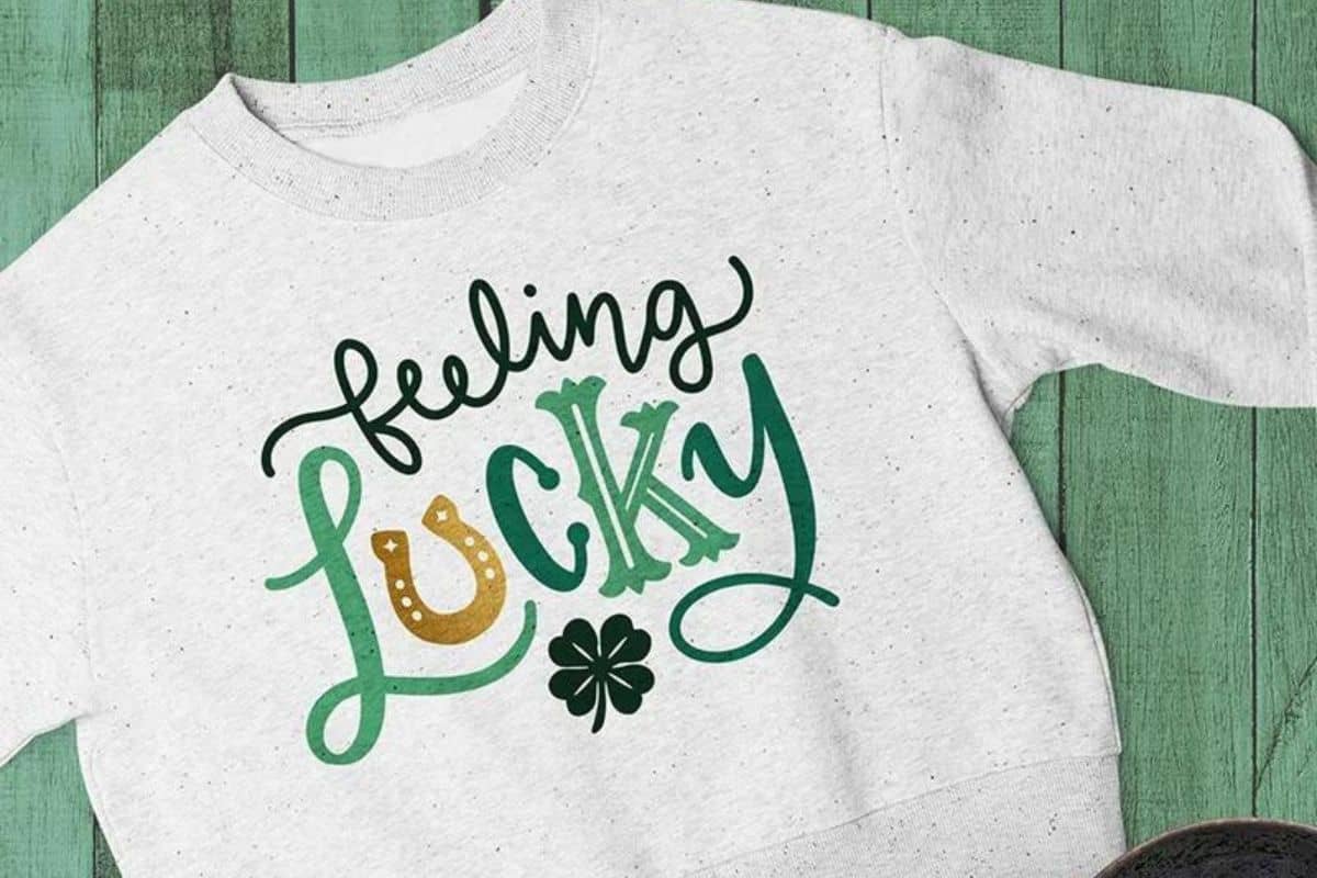 A white sweatshirt with a design that reads feeling lucky.