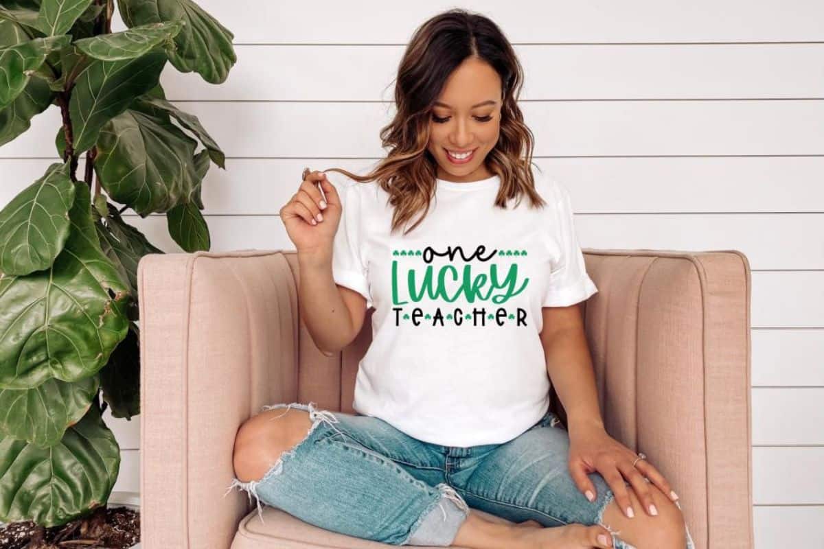 A white shirt with a design that reads one lucky teacher.