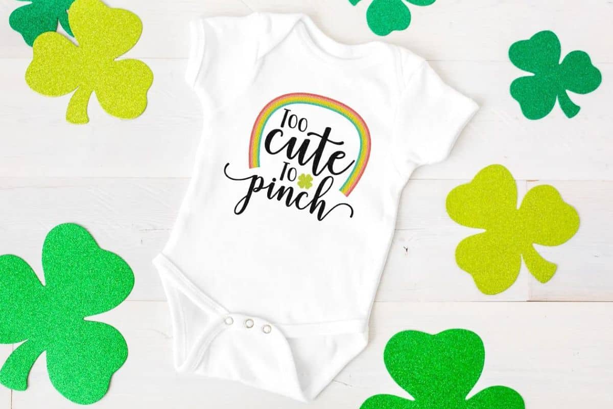 A white onesie with a design that reads too cute to pinch.