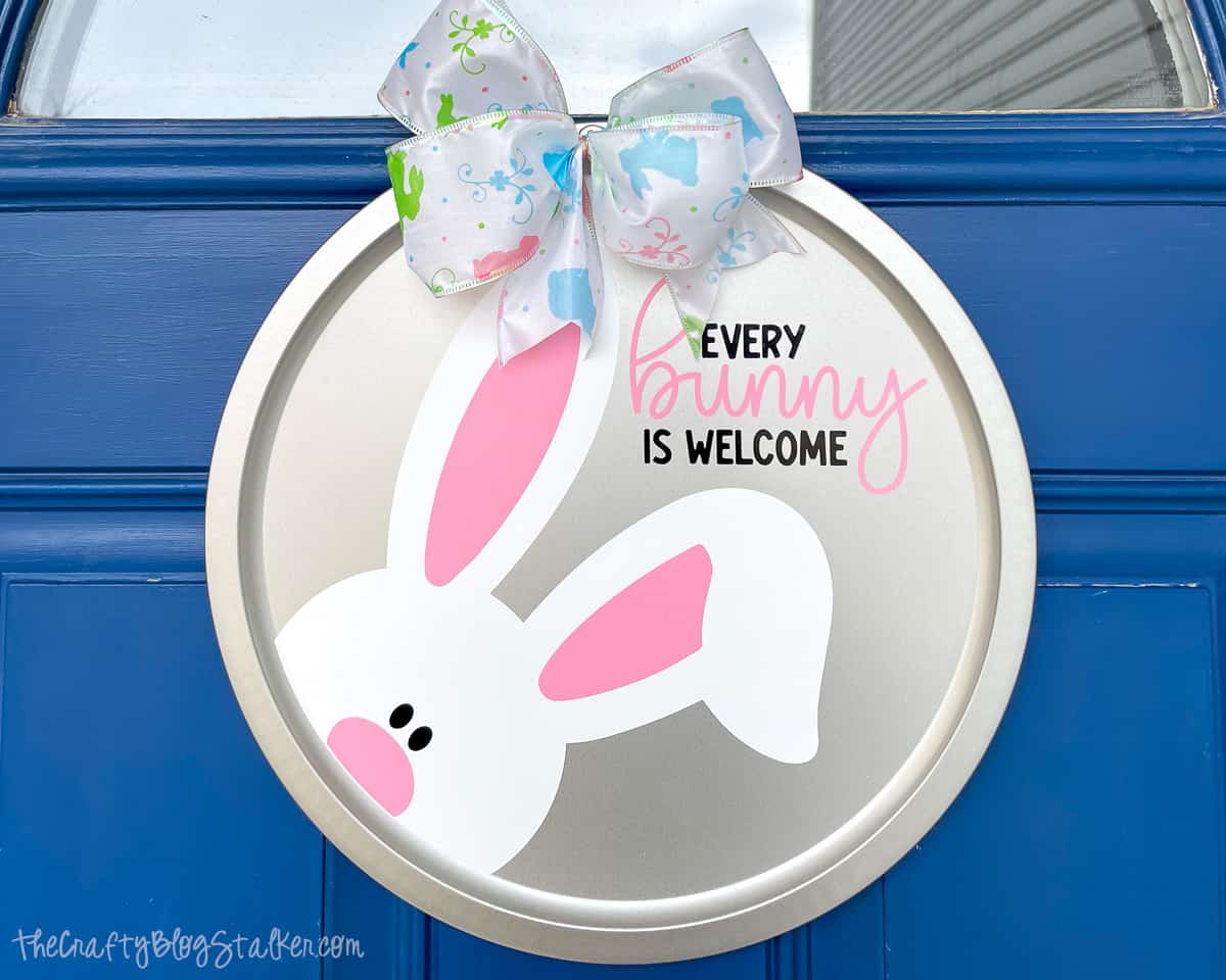 Every bunny is welcome door hanger on a blue front door.