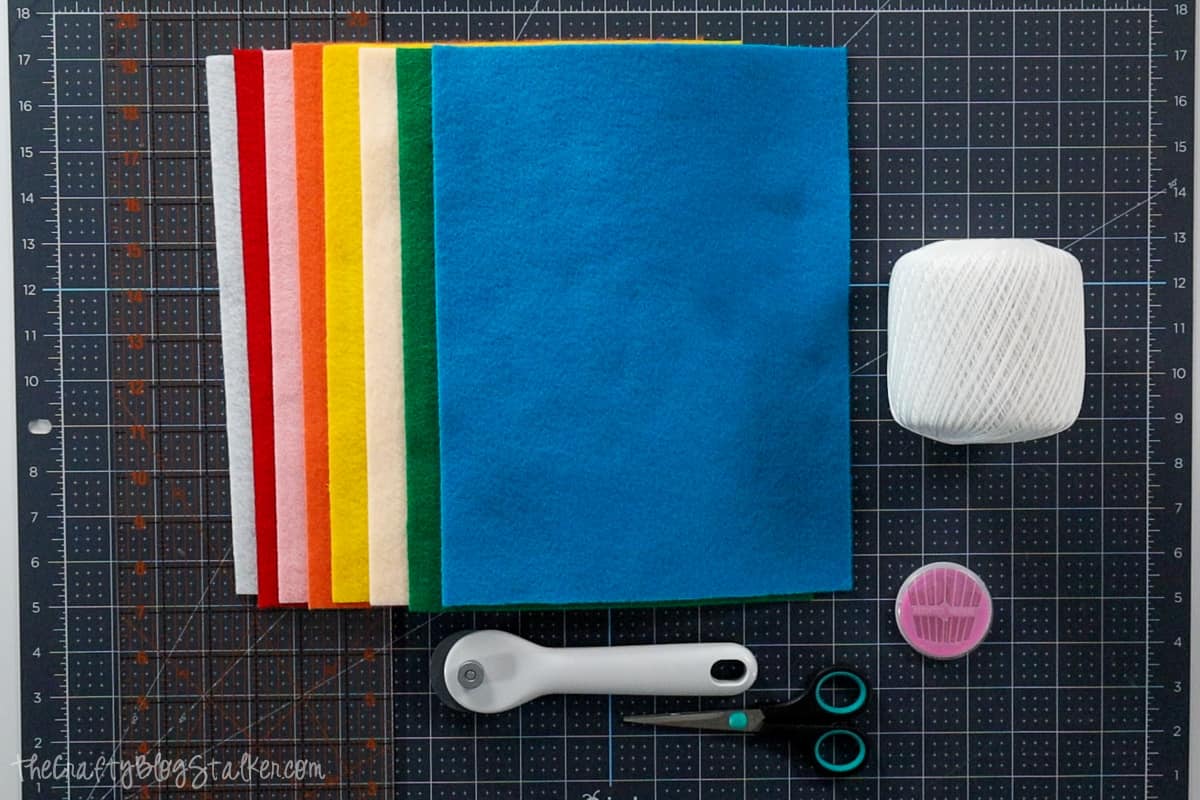 Sheets of felt in 8 colors, crochet thread, needles, scissors, rotary cutter, self-healing mat, and a quilting ruler.