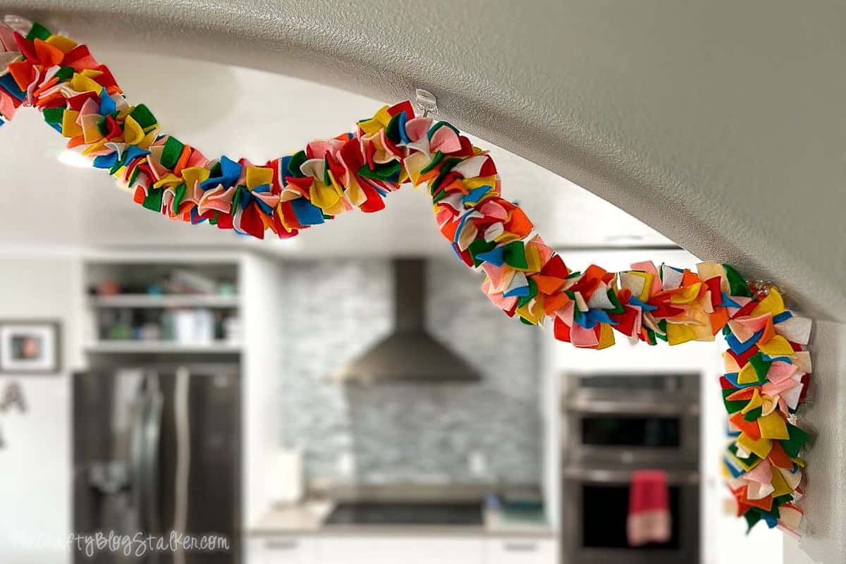 Colorful felt garland hanging on a ledge.