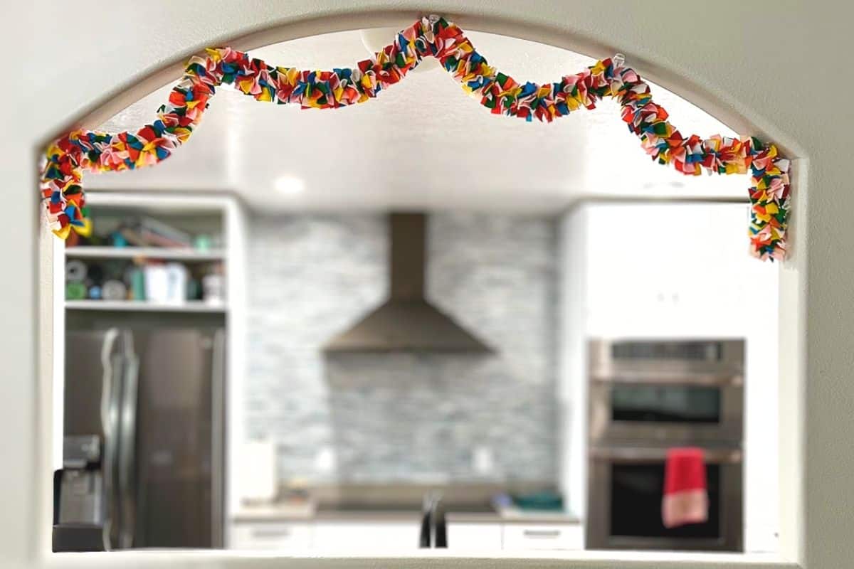 A felt garland hanging in a kitchen window.