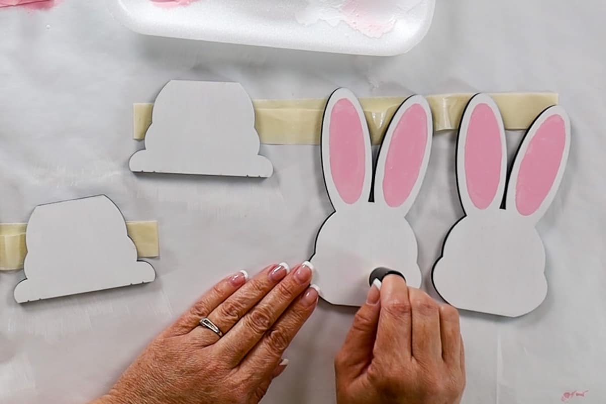 Adding rosy cheeks to the bunnies with a paint dauber.