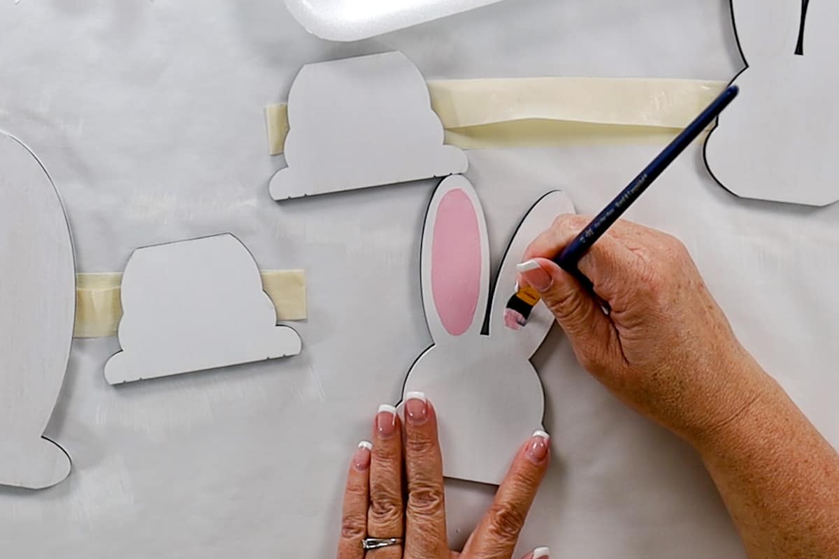 Painting the bunny ears pink with a small flat paintbrush.