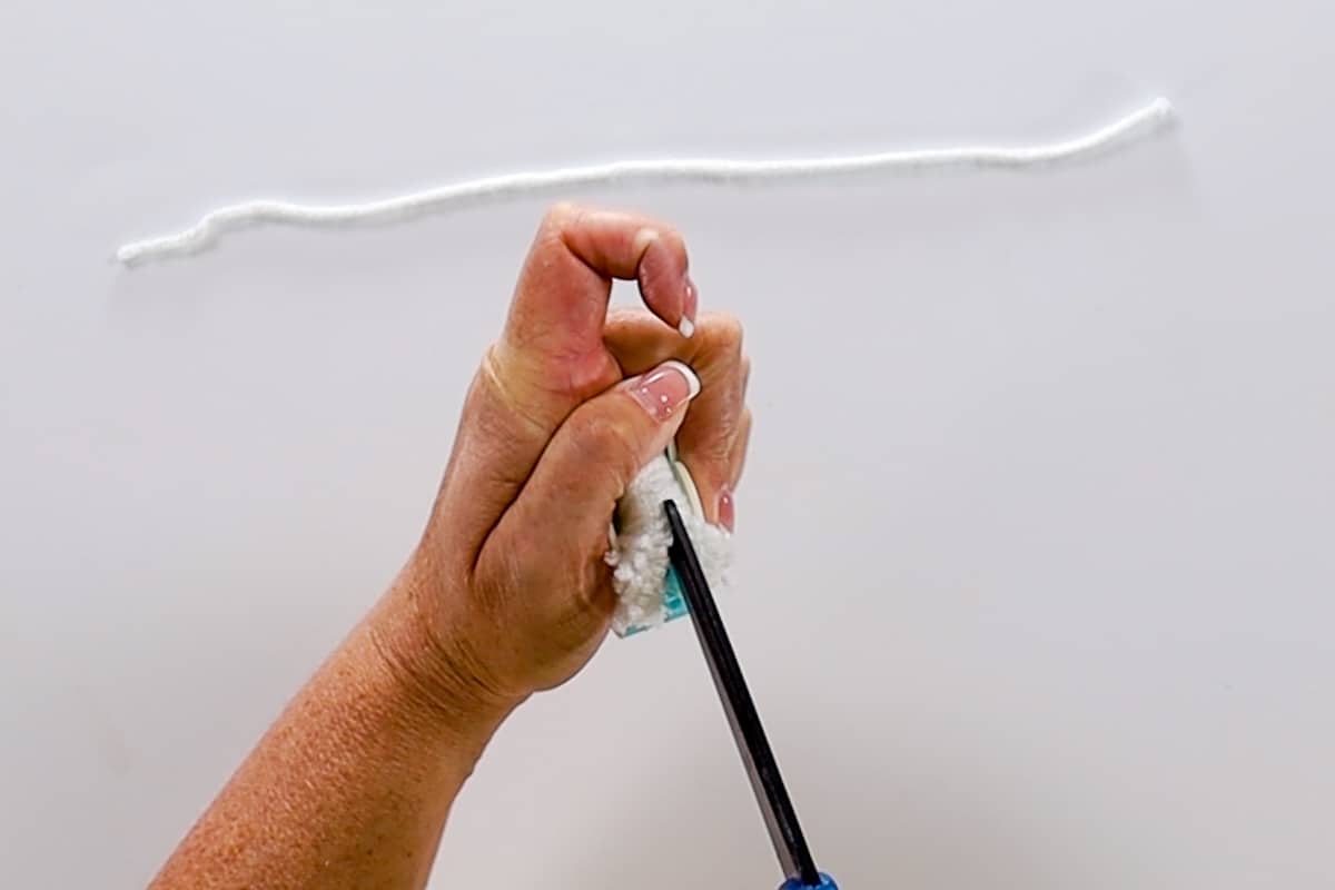 Cutting down the slits in the pom pom maker.