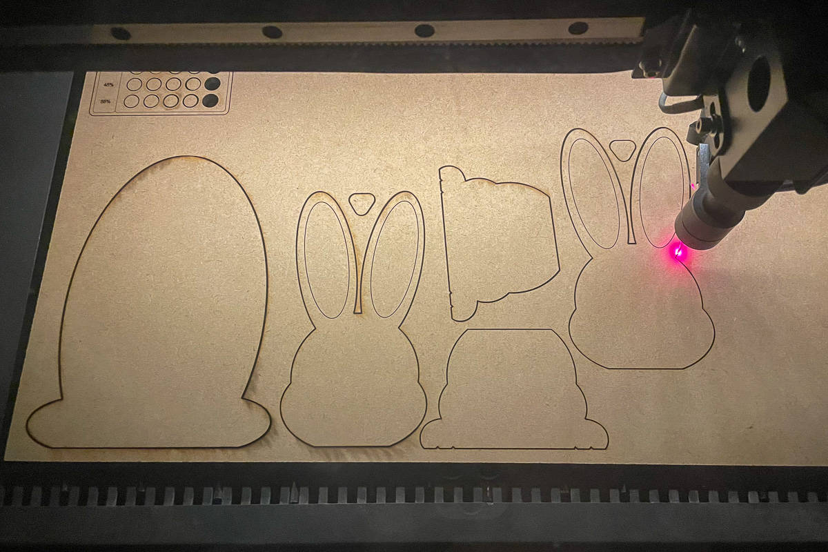 Laser cutting the bunny shapes out of MDF.