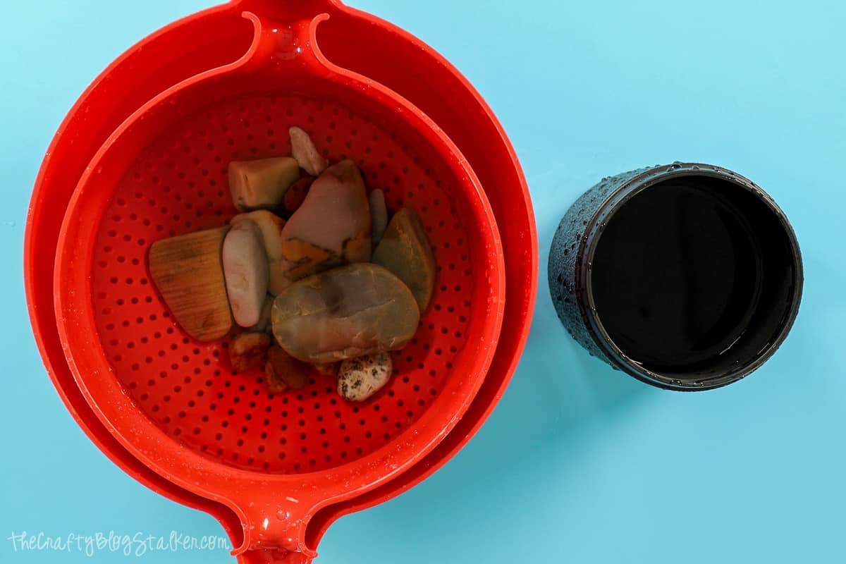 Rocks in a red bowl of water.