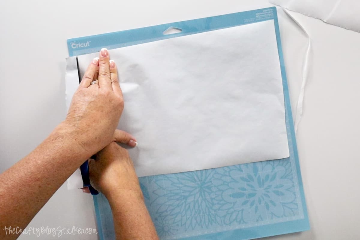 Cutting freezer paper to size with a pair of scissors.
