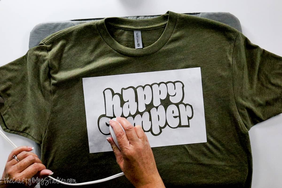 Ironing the happy camper stencil onto a t-shirt with the EasyPress mini,