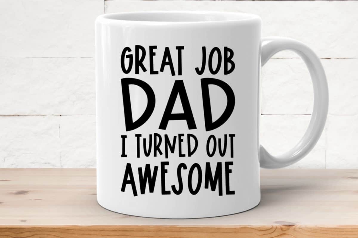 A white coffee mug with a design that reads "Great job dad I turned out awesome".