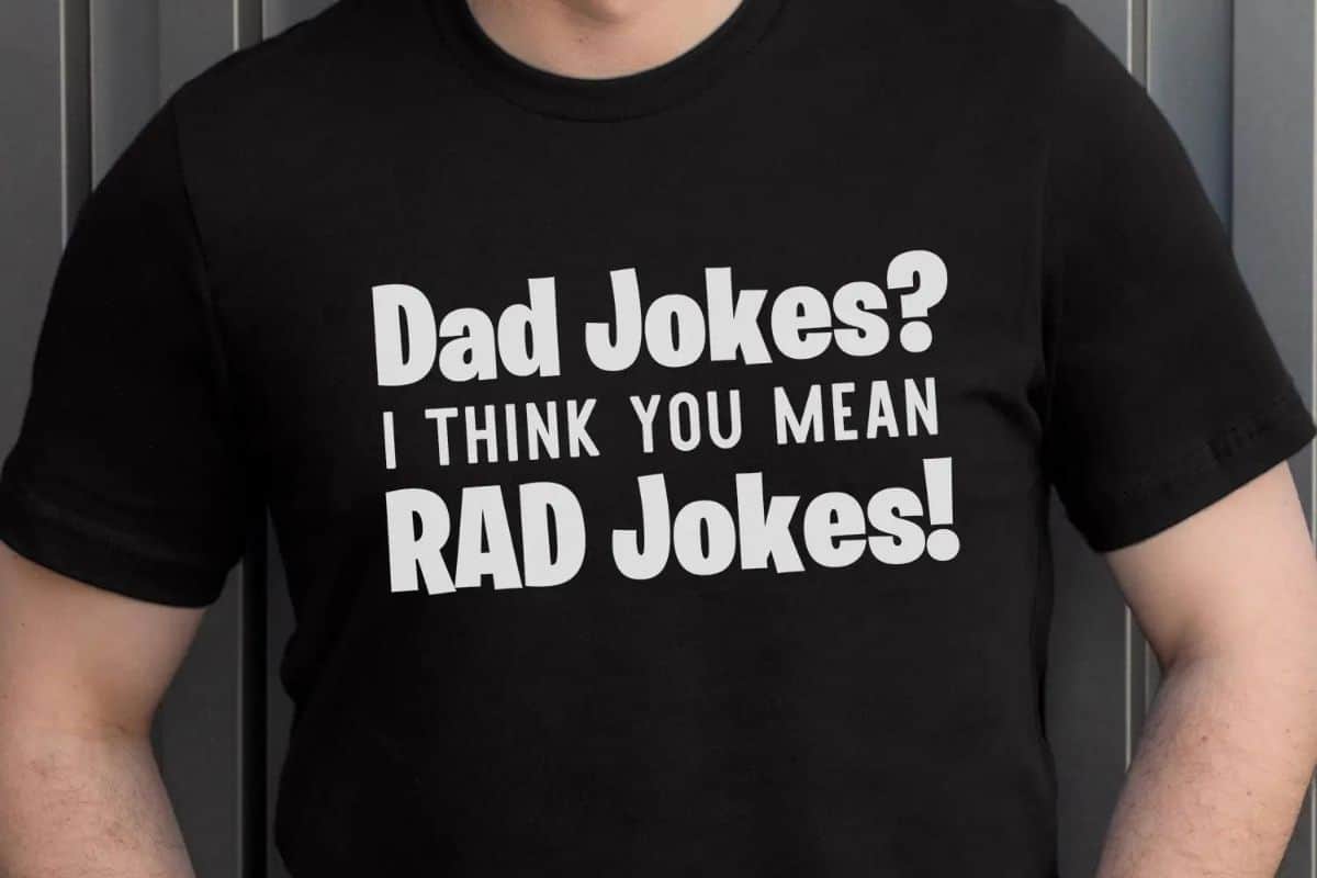 A man wearing a black t-shirt with a design that reads "Dad Jokes? I think you mean rad jokes!".