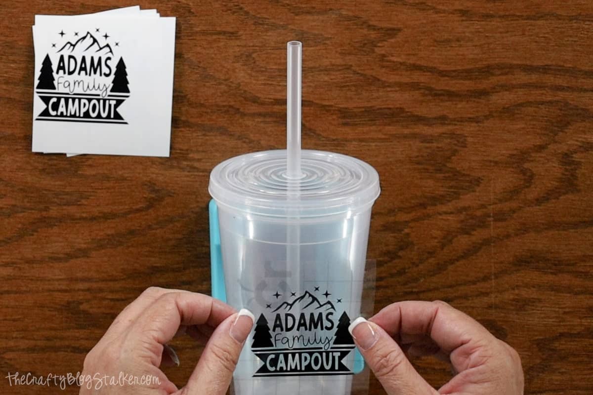Placing a vinyl decal on a plastic cup.