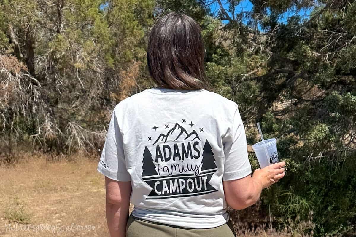 A woman wearing a t-shirt that says Adams Family Campout.
