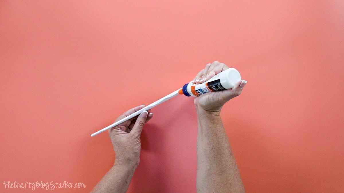 Applying a bead of glue to the length of paper wand.