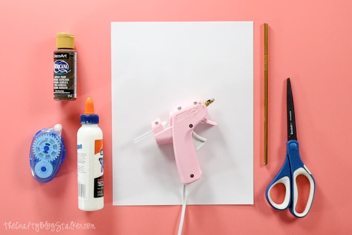 Craft Supplies: paper, hot glue gun, scissors, metal straw, school glue, and paint.