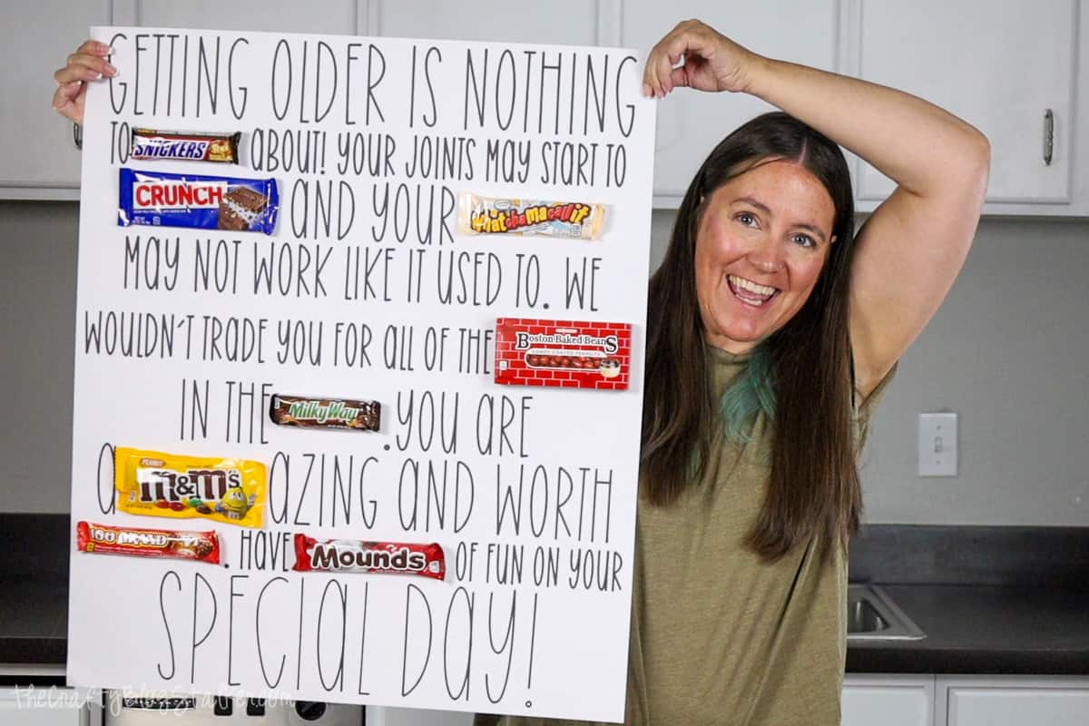A woman holding up a birthday candy poster.