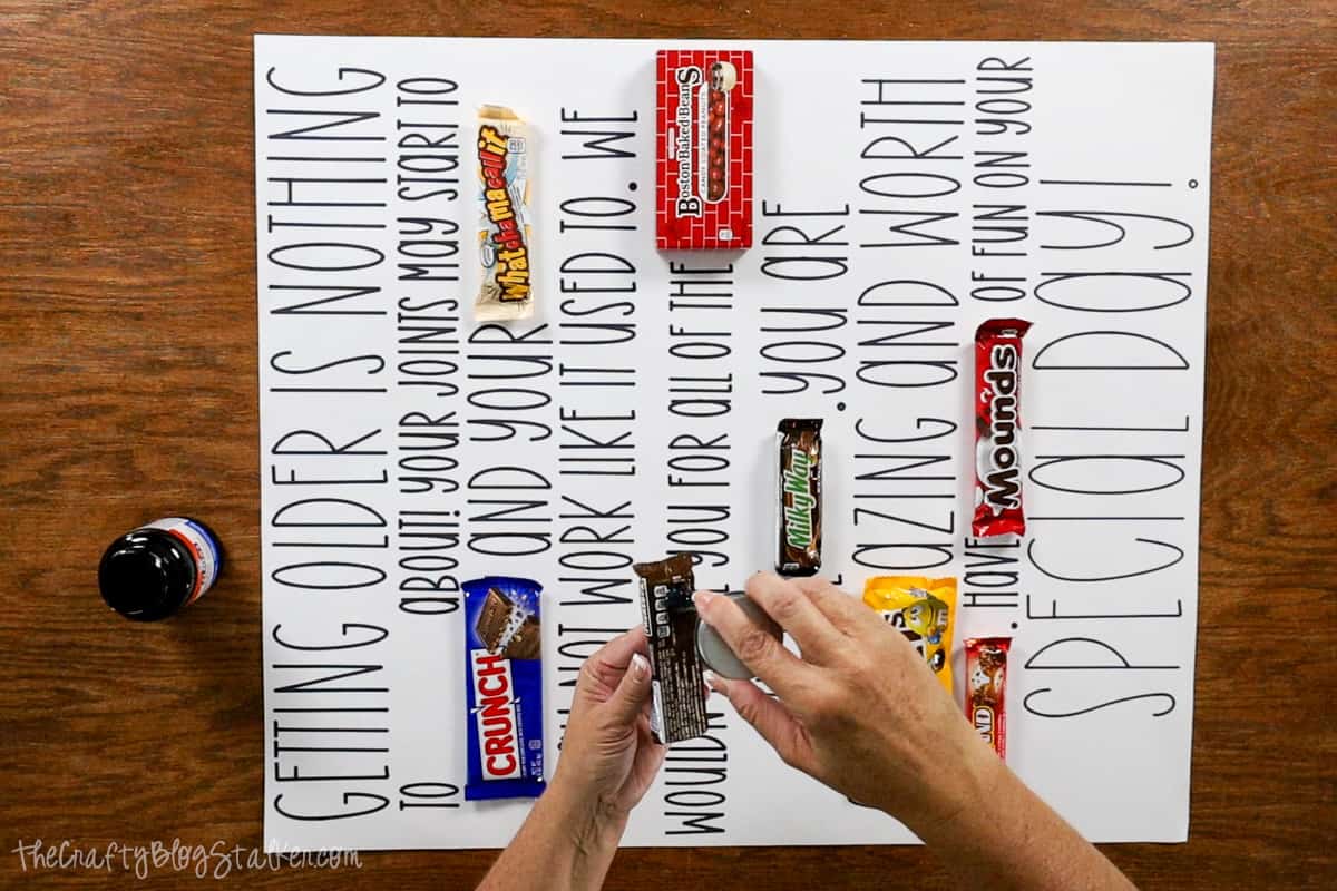 Applying rubber cement to the back of the candy bars to stick them to the birthday poster.
