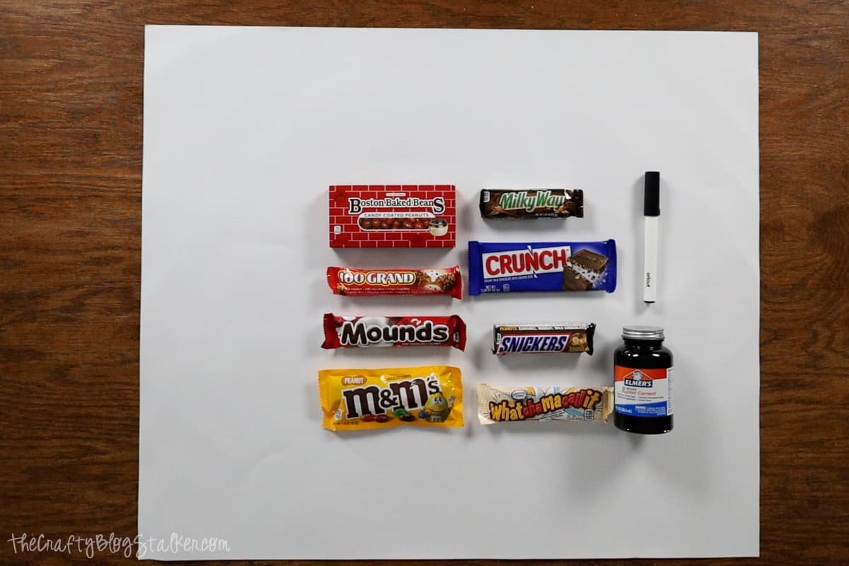 White poster board, black permanent marker, and candy bars to make a candy poster.