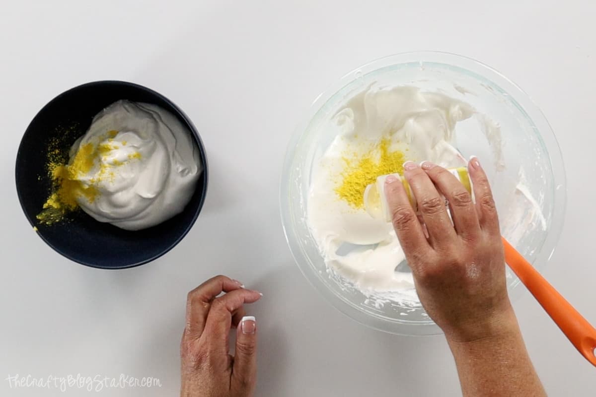 Adding yellow mica powder to two bowls of soap micture.