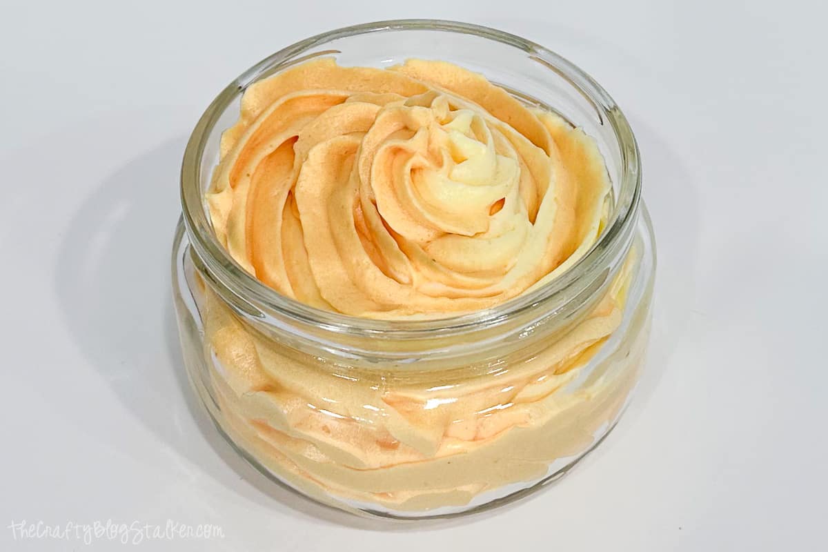 A glass jar filled with exfoliating whipped soap.