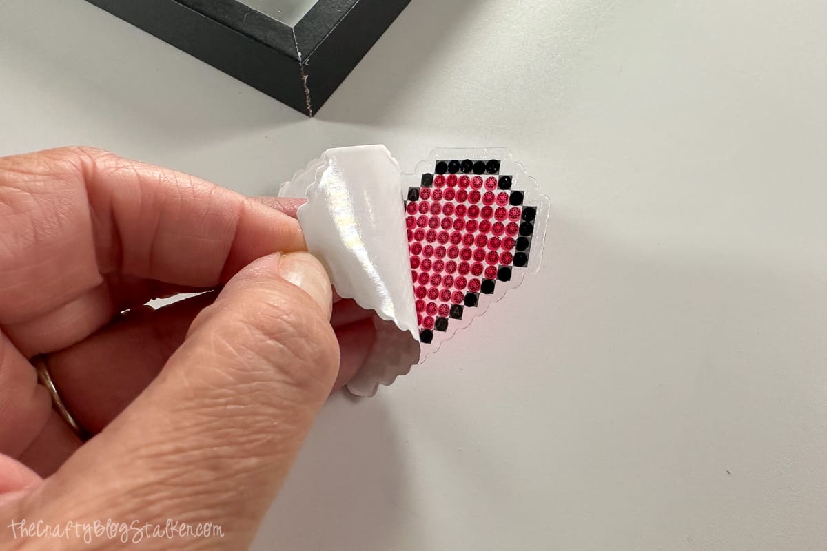 Removing the backing to the diamond art sticker.