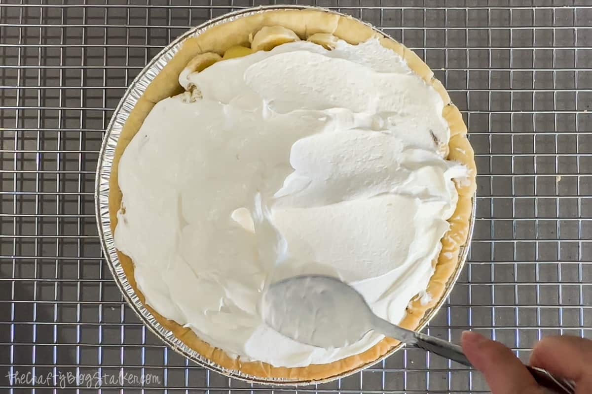 Covering the pie with cool whip.