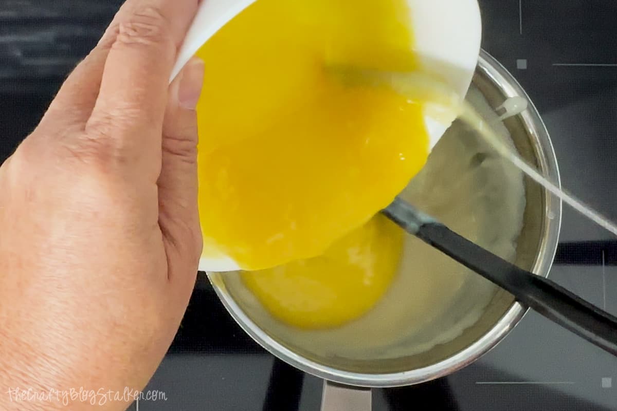 Pouring egg mixture back into the saucepan.