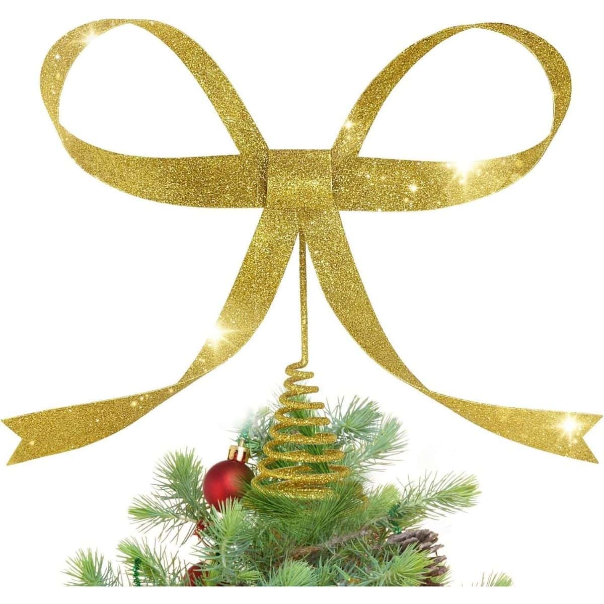 Large glittery gold bow tree topper with long ribbon tails and a spiral base, placed on top of a decorated Christmas tree with red ornaments.