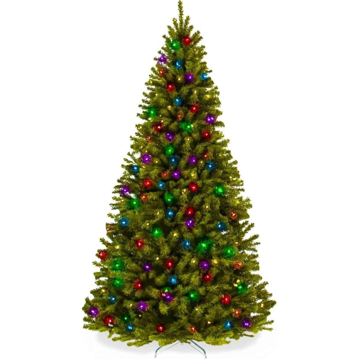 Artificial spruce Christmas tree decorated with colorful red, green, blue, and purple lights, standing tall on a green metal stand against a white background.