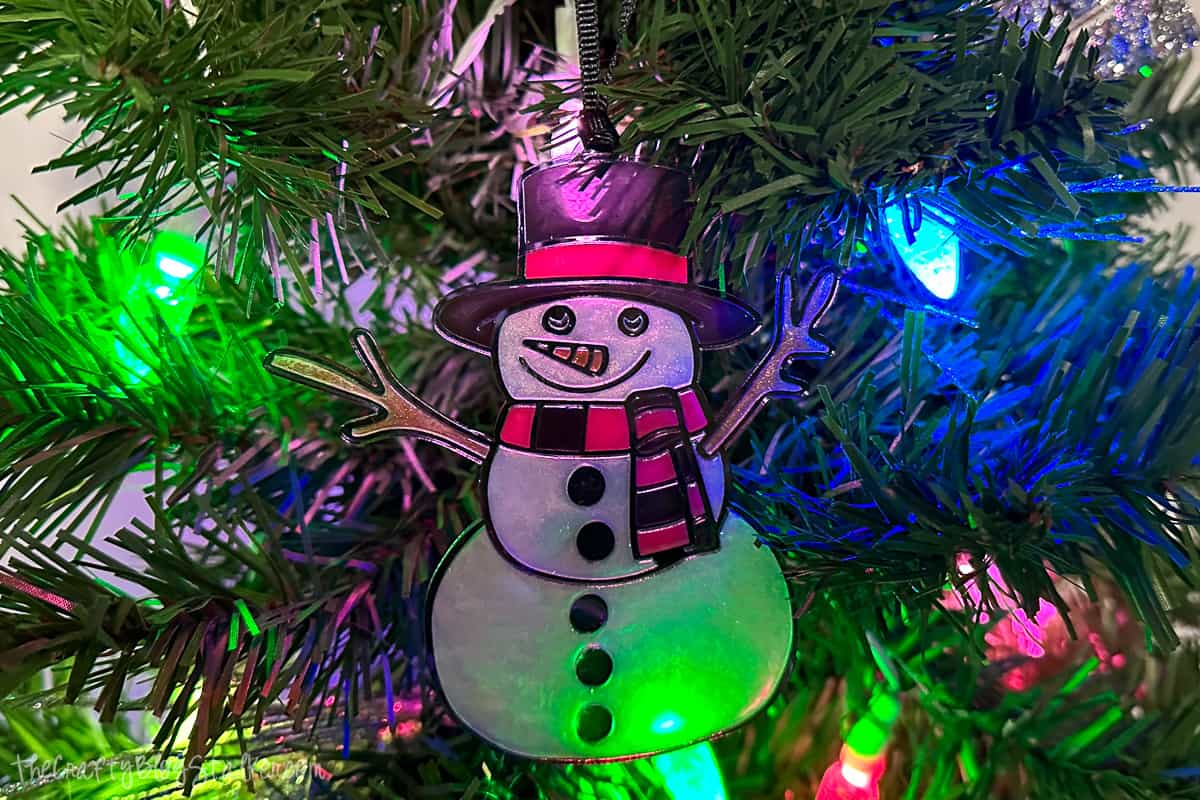 Faux stained glass ornament hanging on a Christmas tree.