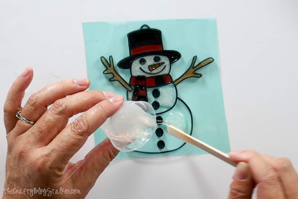 Adding white resin to the snowman base.