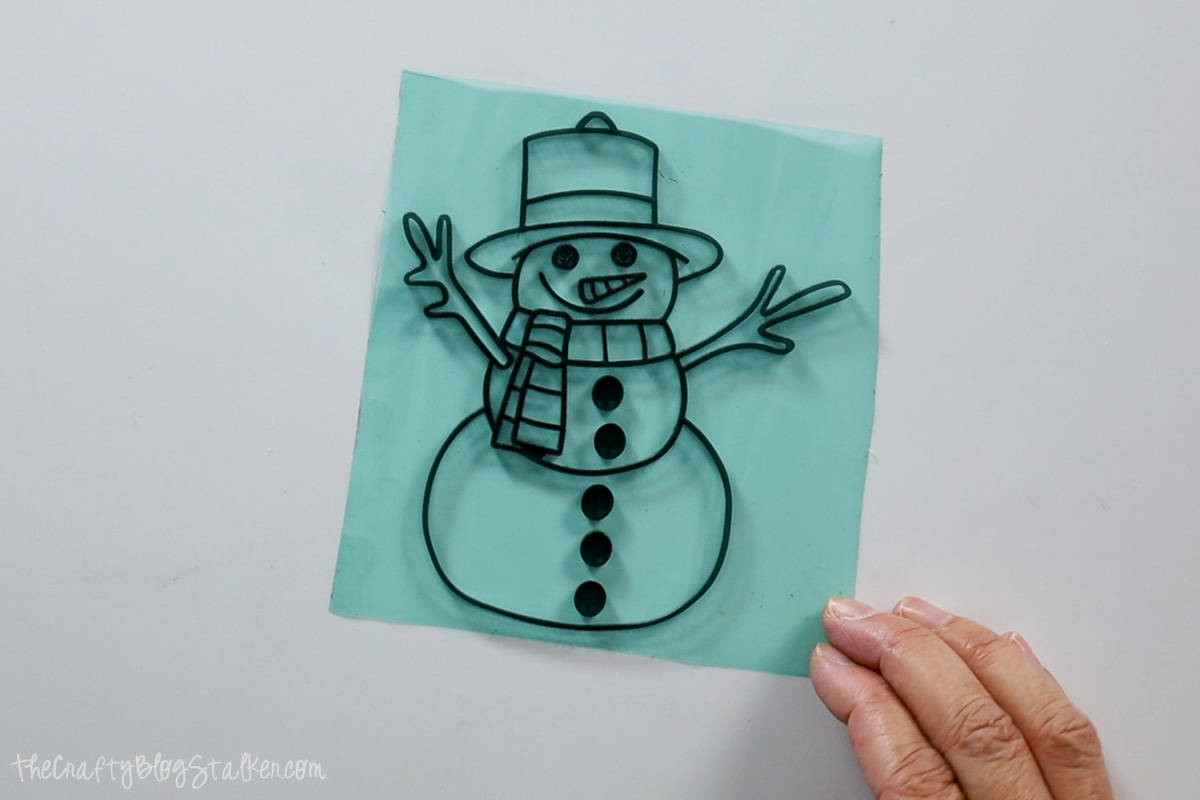 Acrylic snowman outline on resin tape.