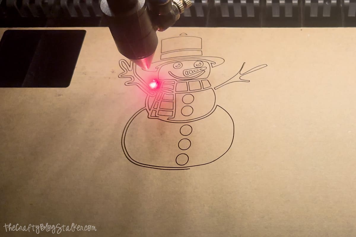 Laser cutting snowman ornament.